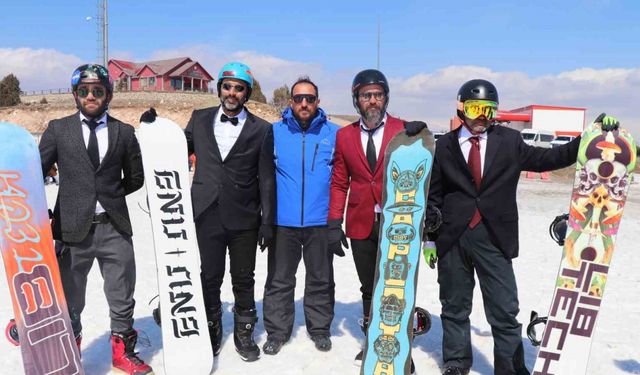 Kayak sezonunu takım elbiseyle snowboard yaparak uğurladılar