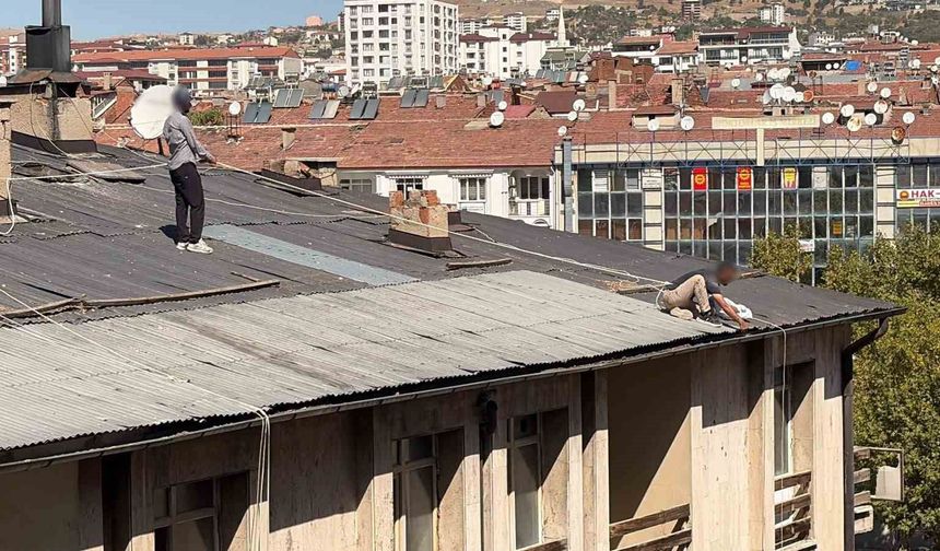 Çatıda oluk temizliği yapan şahıs, beline halat bağlayarak güvenlik önlemi aldı